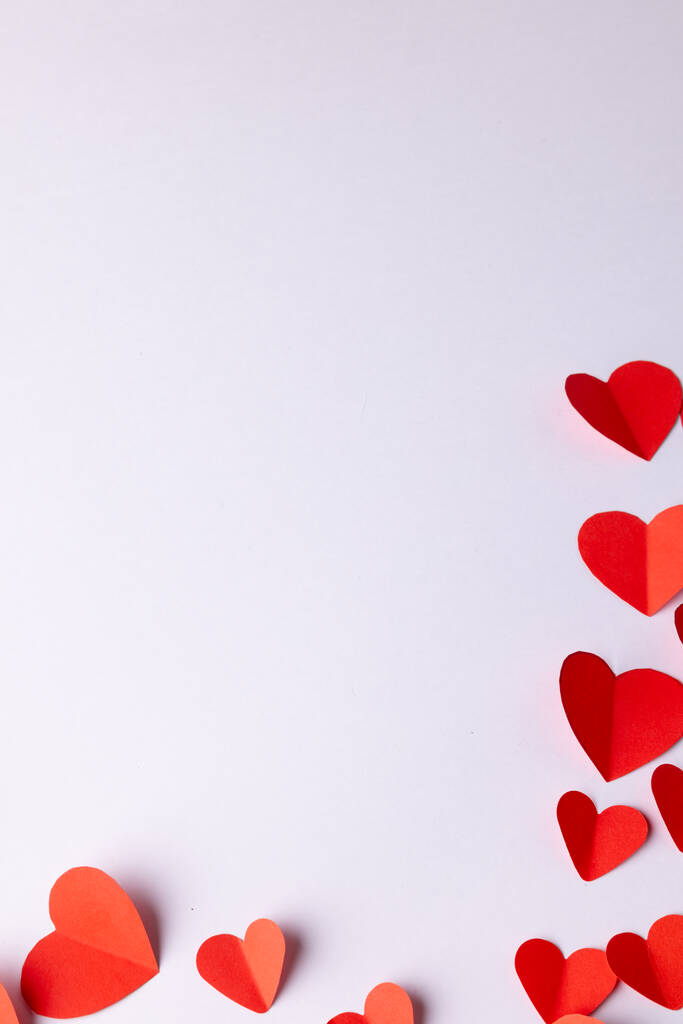 コピースペースと白い背景に赤い紙のハート型の垂直画像。バレンタインデー、愛、ロマンス、お祝いのコンセプト. - 写真・画像