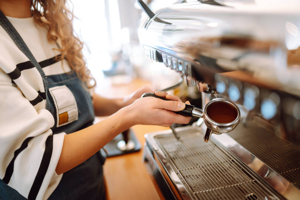 Chica barista preparando delicioso café caliente fresco en la máquina de café profesional. Comida para llevar. - Foto, imagen