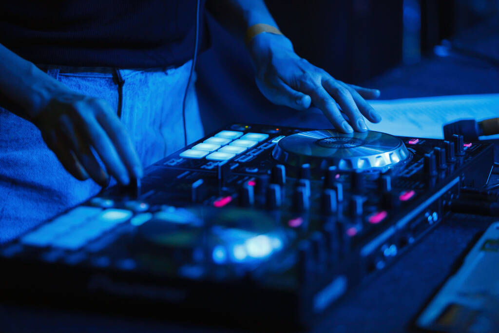 DJ féminin jouant de la musique dans une boîte de nuit. Disc jockey femme joue hip hop en concert en boîte de nuit.  - Photo, image