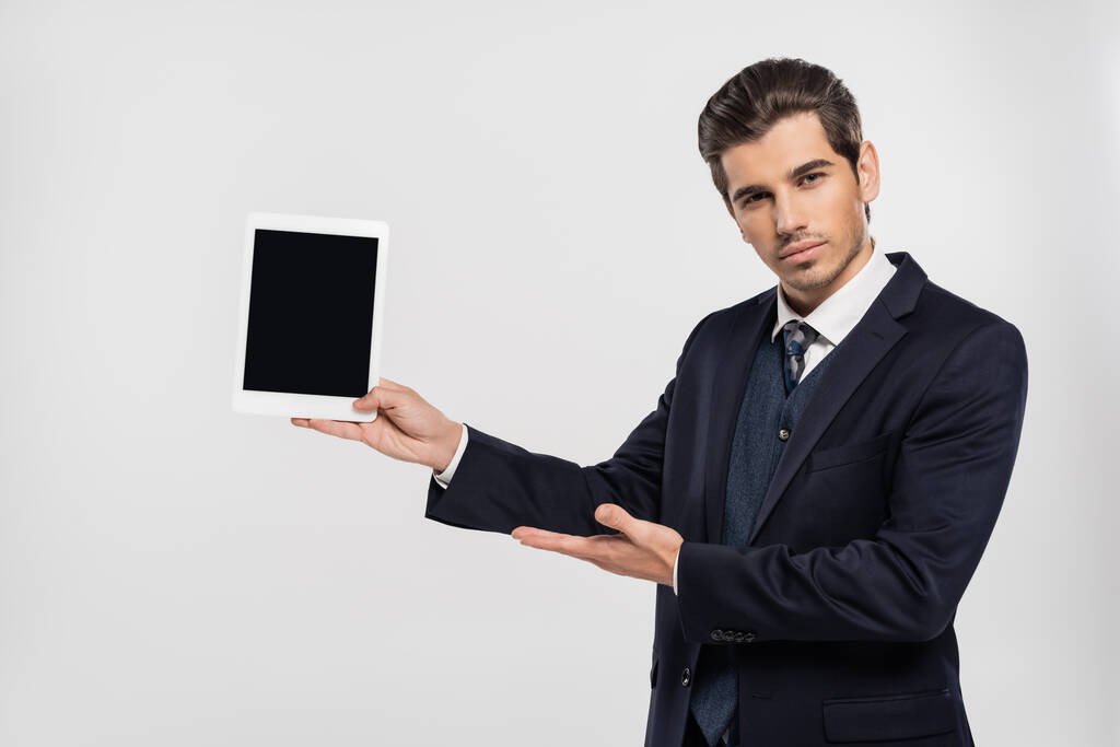 empresário em terno segurando tablet digital com tela em branco isolado em cinza  - Foto, Imagem