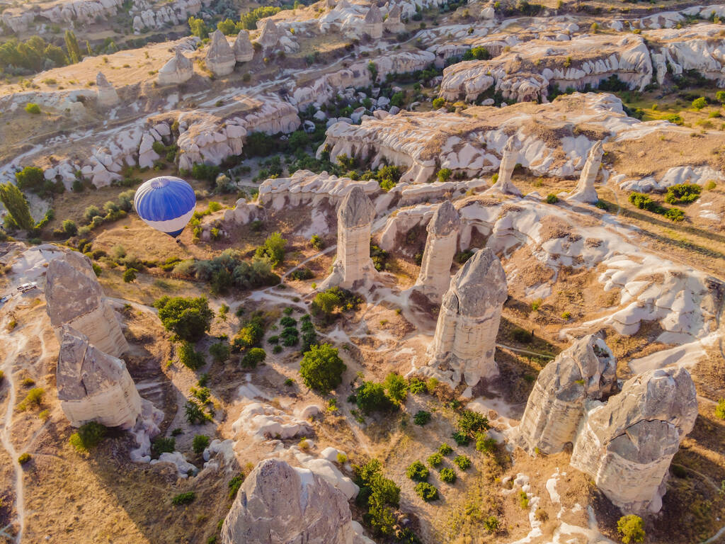 Πολύχρωμα αερόστατα θερμού αέρα πετούν πάνω από την κοιλάδα νεράιδα καμινάδες σε Nevsehir, Goreme, Καππαδοκία Τουρκία. Εντυπωσιακή πανοραμική θέα drone της υπόγειας πόλης και ballooning τουρισμού. Υψηλή ποιότητα. - Φωτογραφία, εικόνα