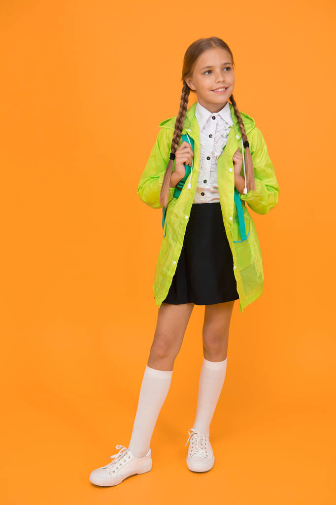 Regen ist kein Hindernis. wasserdichter Mantel. Schulmädchen tragen grünen Regenmantel, wenn sie zur Schule gehen. wasserdichter Stoff für Ihren Komfort. regendichtes Zubehör. wasserdichte Kleidung. Kind Mädchen glücklich tragen Regenmantel. - Foto, Bild