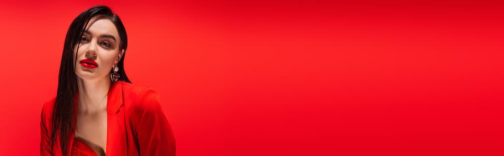 Retrato de jovem morena de casaco olhando para câmera isolada em vermelho, banner  - Foto, Imagem