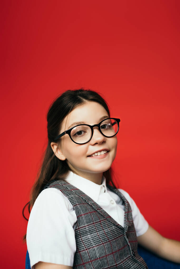 muotokuva iloinen brunette tyttö silmälasit hymyillen kameran eristetty punainen - Valokuva, kuva