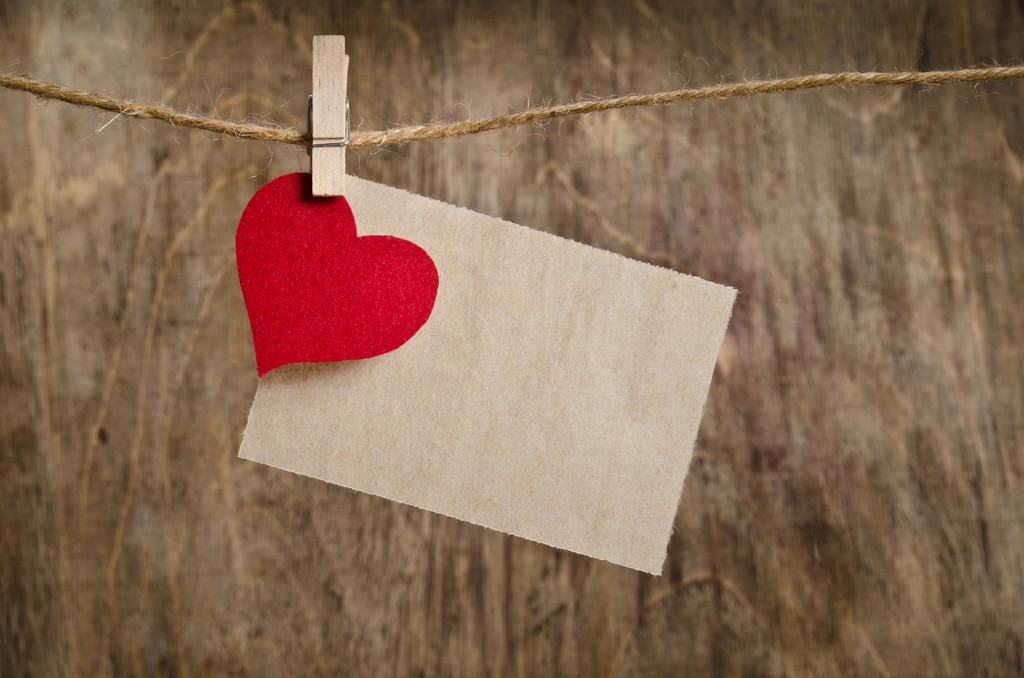 Corazón de tela roja con hoja de papel colgada en el tendedero
. - Foto, imagen