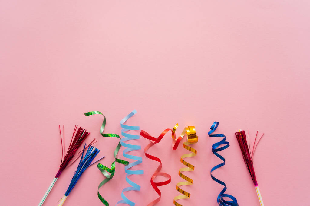 Top view of serpentine and drinking straws with tinsel on pink background  - Photo, Image