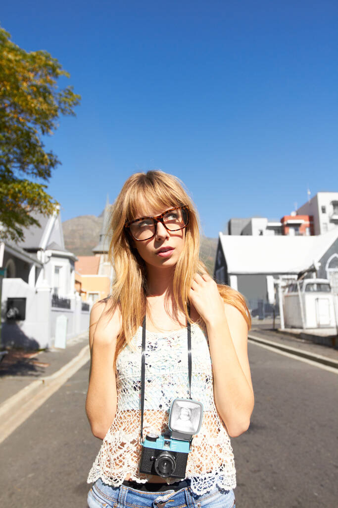 Ищу идеальный снимок. Модная молодая девушка, стоящая посреди тихой дороги с винтажной камерой - Фото, изображение
