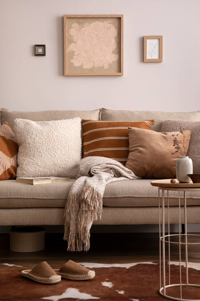 L'elegante composizione di interni soggiorno con divano beige con cuscino, plaid, tavolino e accessori personali. parete beige con poster finto. Arredo casa. Modello.. - Foto, immagini