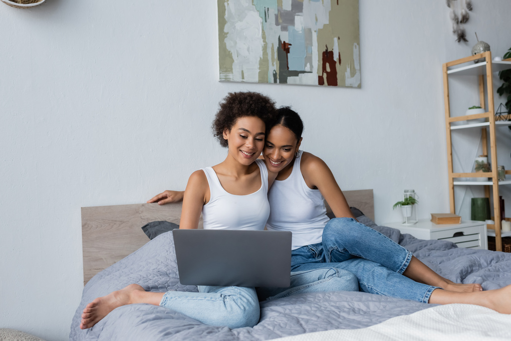 Africain américain lesbienne couple regardant ordinateur portable tout en regardant le film dans la chambre - Photo, image