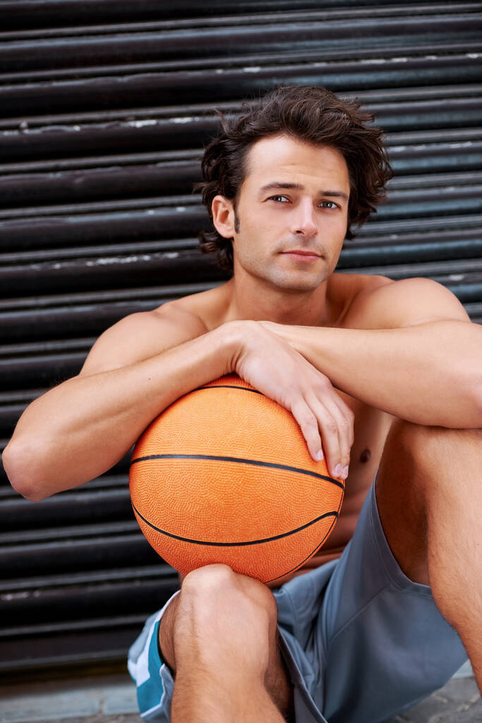 Sadece ballin. Dışarıda elinde basketbol topuyla oturan yakışıklı bir sporcu. - Fotoğraf, Görsel