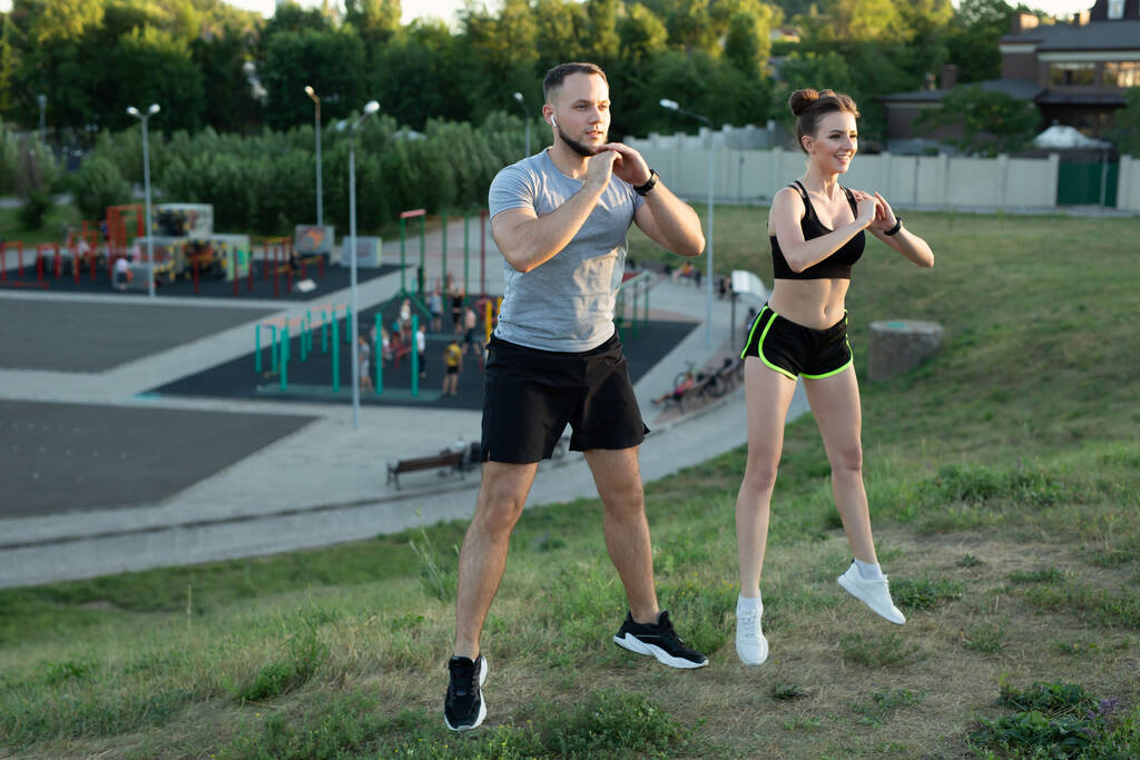 Young couple trains outdoors in a Park in the summer at sunset - Photo, Image