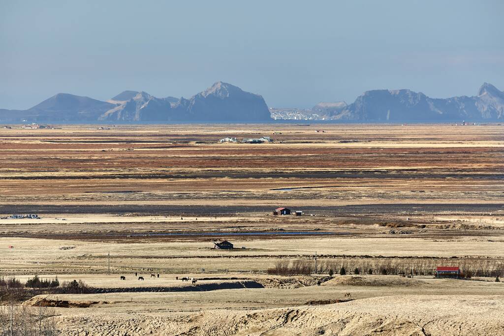Paesaggio pianeggiante islandese con scogliere delle isole Vestmannaeyjar sullo sfondo lontano - Foto, immagini