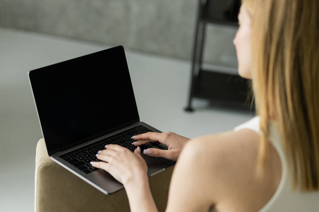 Hämärtynyt blondi freelancer kannettavan tietokoneen tyhjällä näytöllä kotona  - Valokuva, kuva