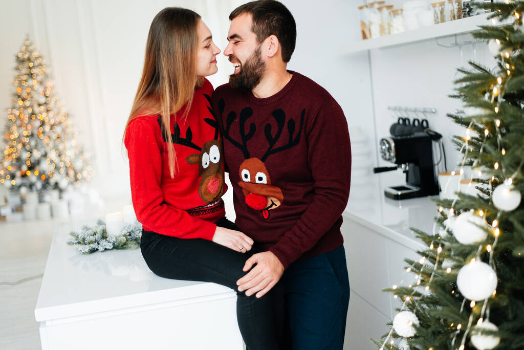 Un couple attrayant ouvre ses cadeaux de Noël près de l'arbre de Noël. - Photo, image