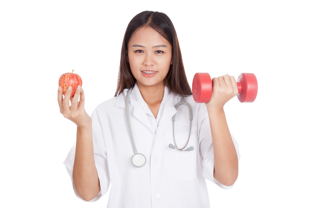 Young Asian female doctor  hold apple and dumbbell - Photo, Image
