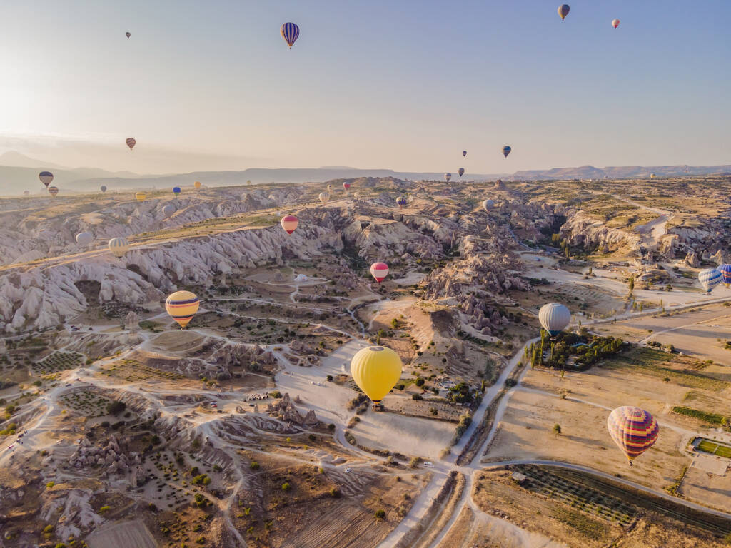 Kleurrijke heteluchtballonnen vliegen over bij fee schoorstenen vallei in Nevsehir, Goreme, Cappadocia Turkije. Spectaculair panoramisch uitzicht op de ondergrondse stad en ballonvaart toerisme. Hoge kwaliteit. - Foto, afbeelding