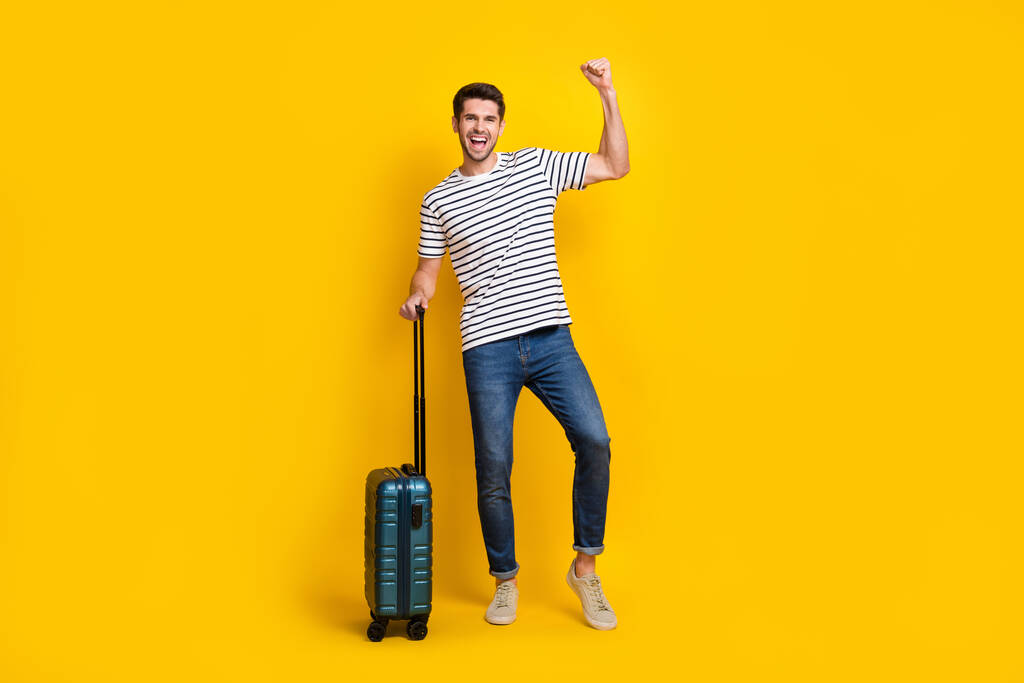Volledige lengte foto van zelfverzekerde gelukkige man dragen witte t-shirt spannende gaan nieuwe reis geïsoleerde gele kleur achtergrond. - Foto, afbeelding