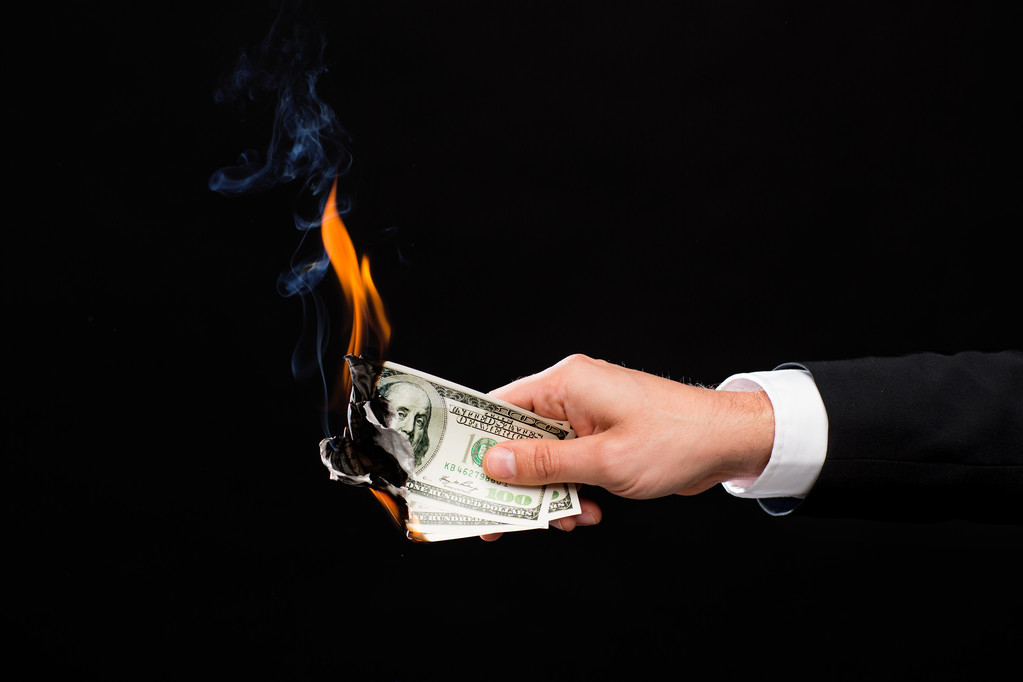 крупным планом мужчины, держащего горящие долларовые деньги
 - Фото, изображение