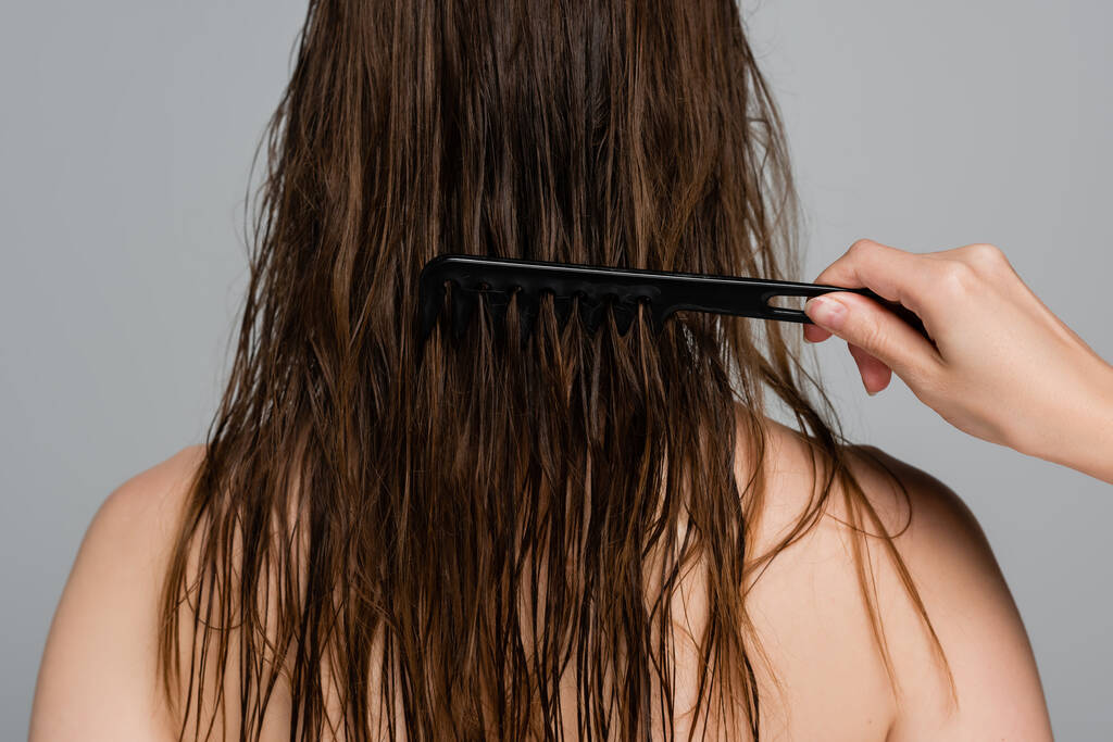 professionele kapper borstelen nat haar van vrouw geïsoleerd op grijs - Foto, afbeelding