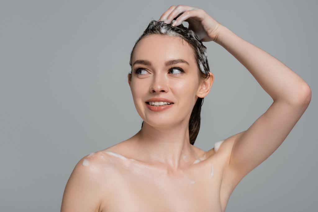 wesoła młoda kobieta myjąca piankowe włosy odizolowane na szarości - Zdjęcie, obraz