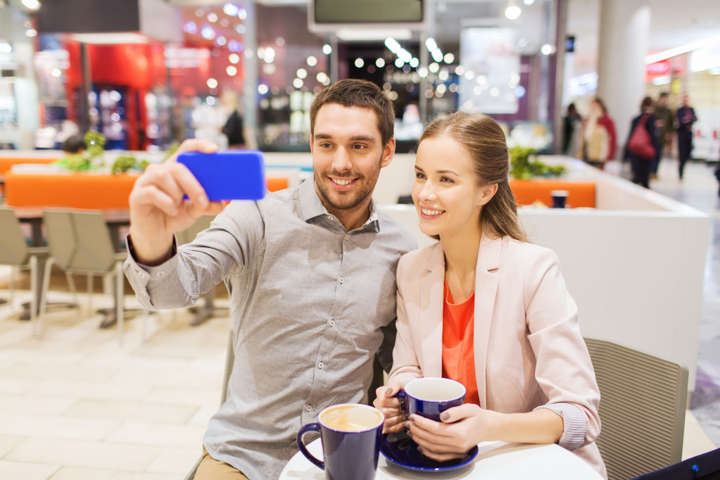 happy couple with smartphone taking selfie in mall - Photo, Image