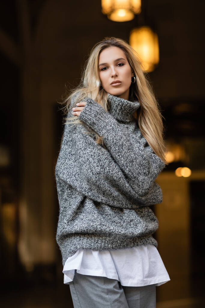 joven rubia en suéter gris de pie con los brazos cruzados en Nueva York  - Foto, Imagen