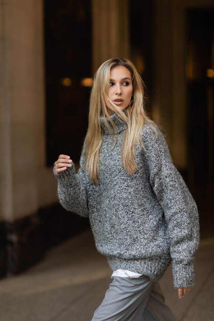 stylish woman in grey knitted sweater looking away on street of New York in winter  - Photo, Image