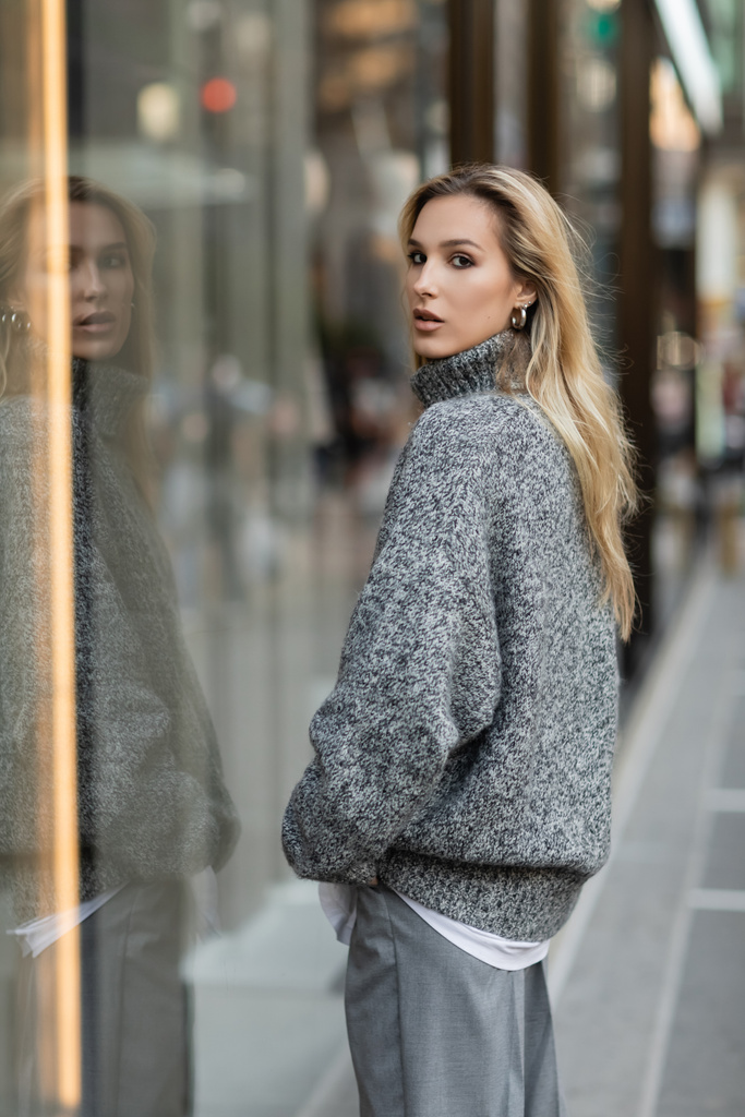 ブロンド女性でグレー冬服立って近くガラス窓ディスプレイでニューヨーク  - 写真・画像