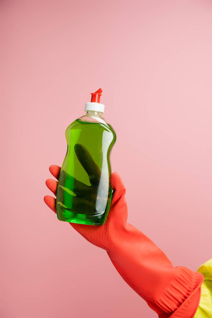 partial view of woman in red rubber glove holding bottle with green detergent isolated on pink - Photo, Image