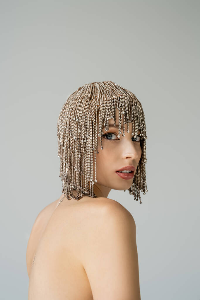 Young woman with naked shoulders and jewelry headwear looking at camera isolated on grey   - Foto, Bild