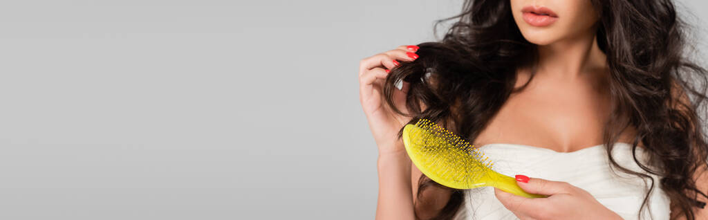 partial view of woman holding hair brush with damaged and lost hair isolated on grey, banner - Photo, Image