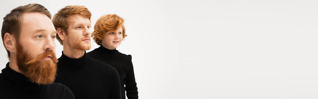 bearded red haired men with smiling boy wearing black turtlenecks and looking away isolated on grey, banner - Foto, Bild