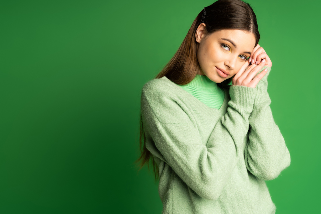 Pretty teen girl posing in soft jumper isolated on green  - Photo, Image