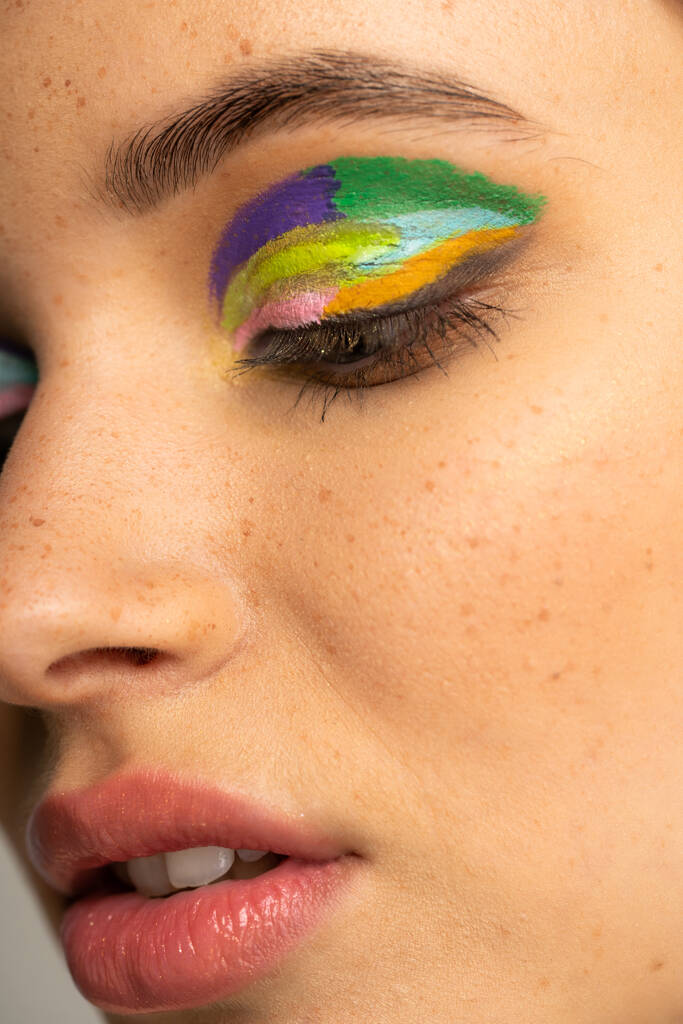Close up view of freckled teenage model with colorful eyeshadows - Fotografie, Obrázek