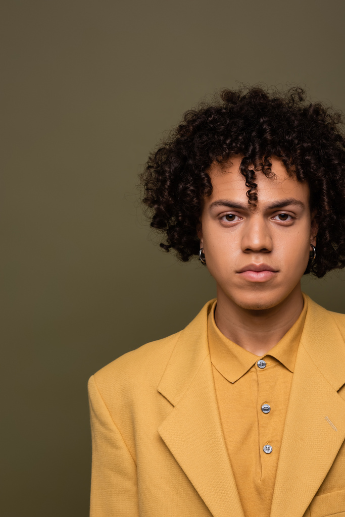 front view of young african american man in yellow blazer and shirt looking at camera isolated on grey - 写真・画像