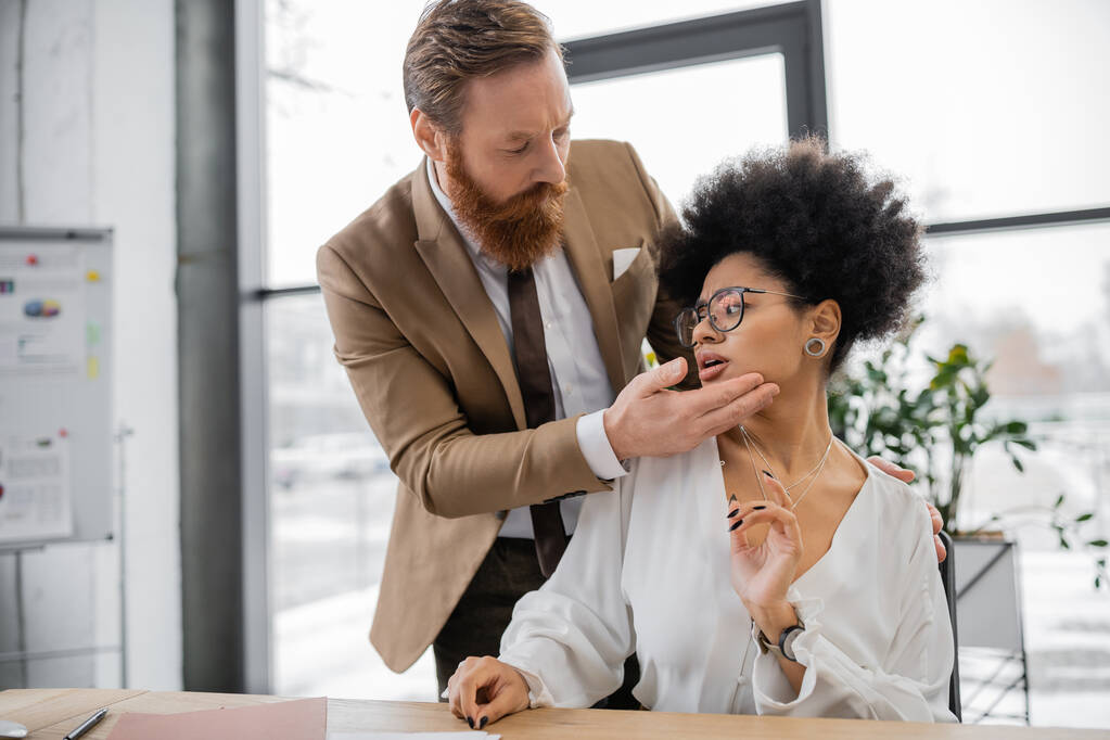 бородатий бізнесмен спокушає кучеряву афроамериканську жінку в офісі
  - Фото, зображення