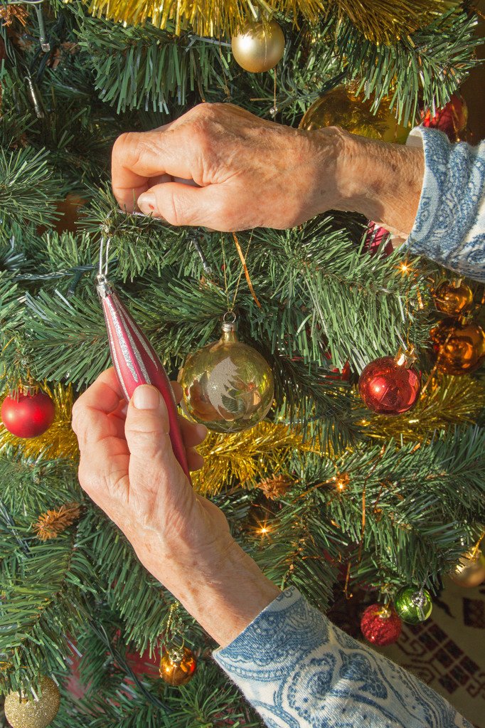 Mãos de mulher velha e decoração de Natal
 - Foto, Imagem