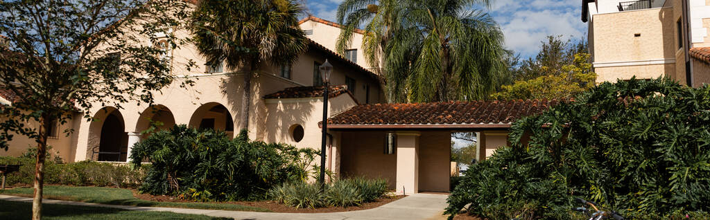 palmbomen in de buurt van luxe mediterrane stijl huis in Miami, banner  - Foto, afbeelding
