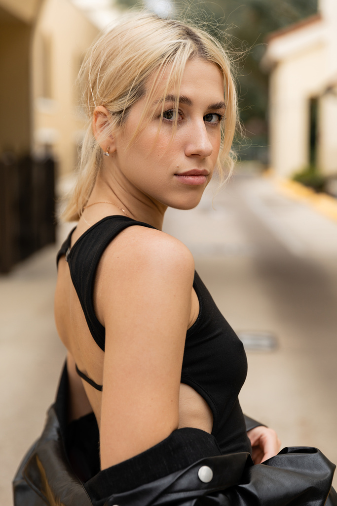 portrét blondýny mladé ženy v černé tílko top při pohledu na kameru venku  - Fotografie, Obrázek