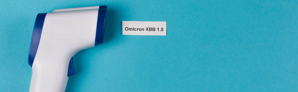 Top view of omicron xbb lettering near pyrometer on blue background, banner  - Foto, afbeelding