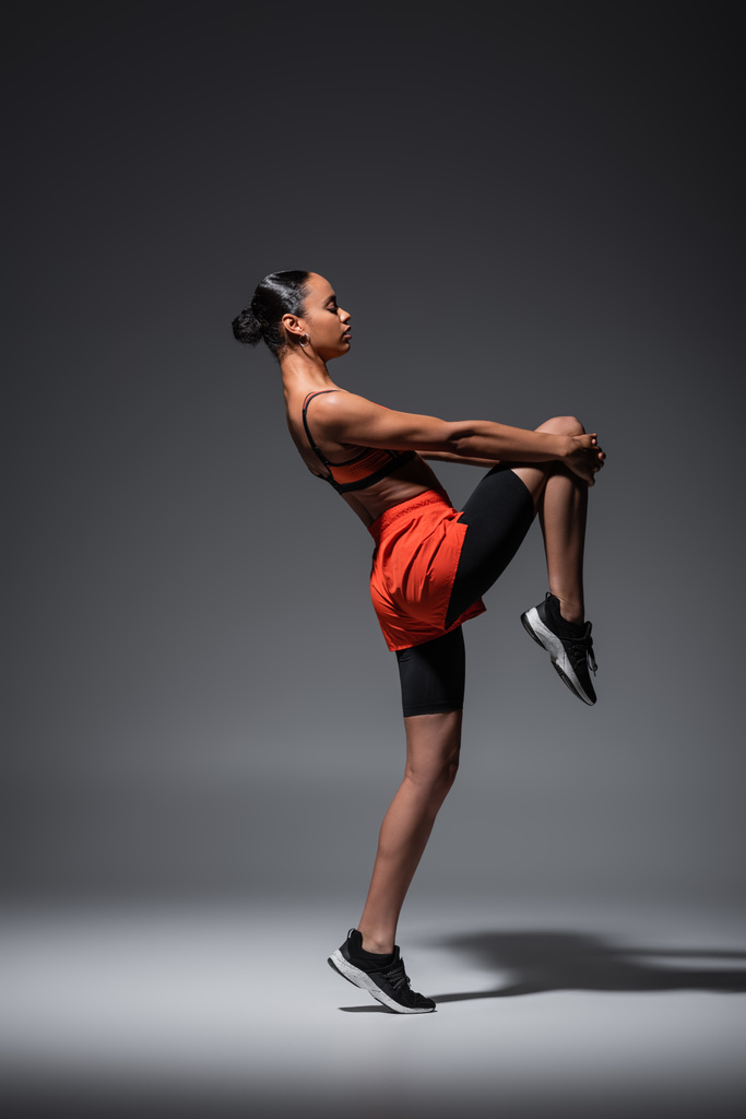 full length of sportive african american woman in sneakers training on grey  - Φωτογραφία, εικόνα