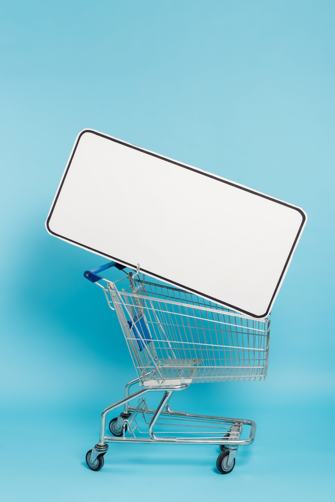 shopping cart with huge template of mobile phone on blue background - Foto, afbeelding