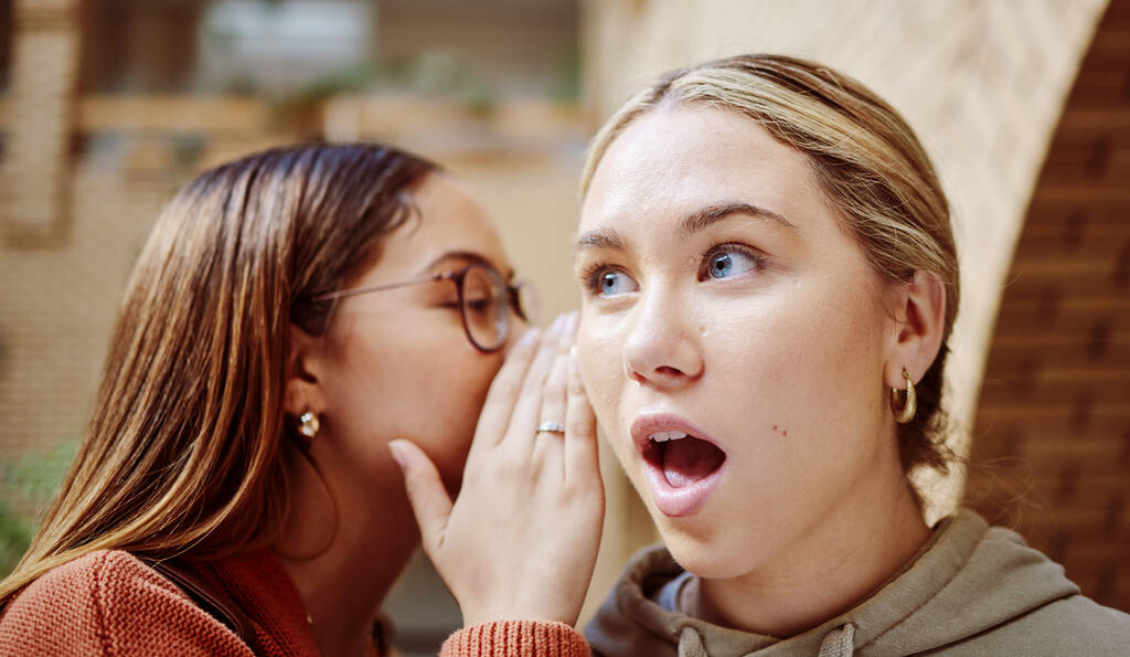 Women gossip, surprise and friends with secret in university campus. Face wow, hands and female students whisper shocking info, gossiping or sharing rumor, secrets or story and chatting in college - Φωτογραφία, εικόνα