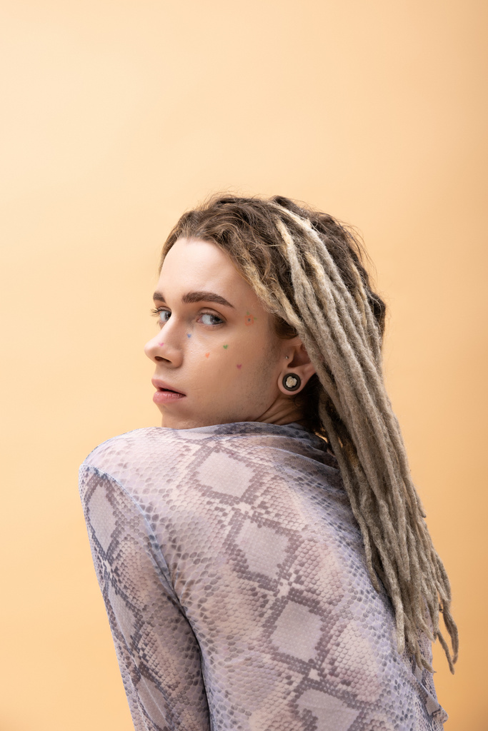 Queer person with dreadlocks looking at camera isolated on yellow  - Zdjęcie, obraz