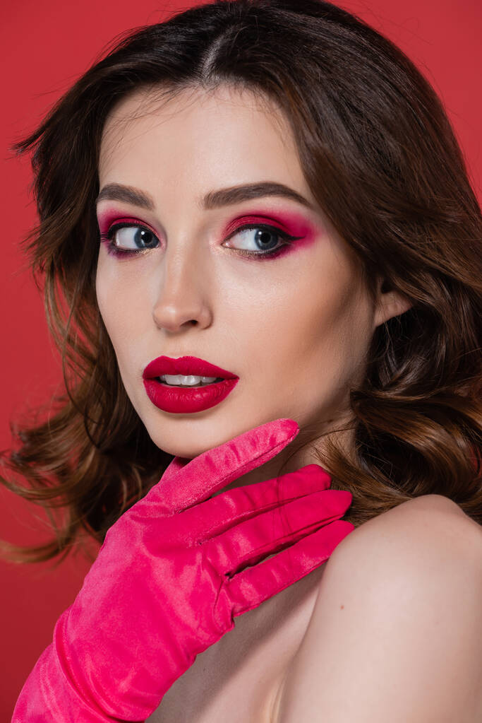 portrait of pretty woman with magenta color eye shadow looking away isolated on pink  - Foto, Imagem