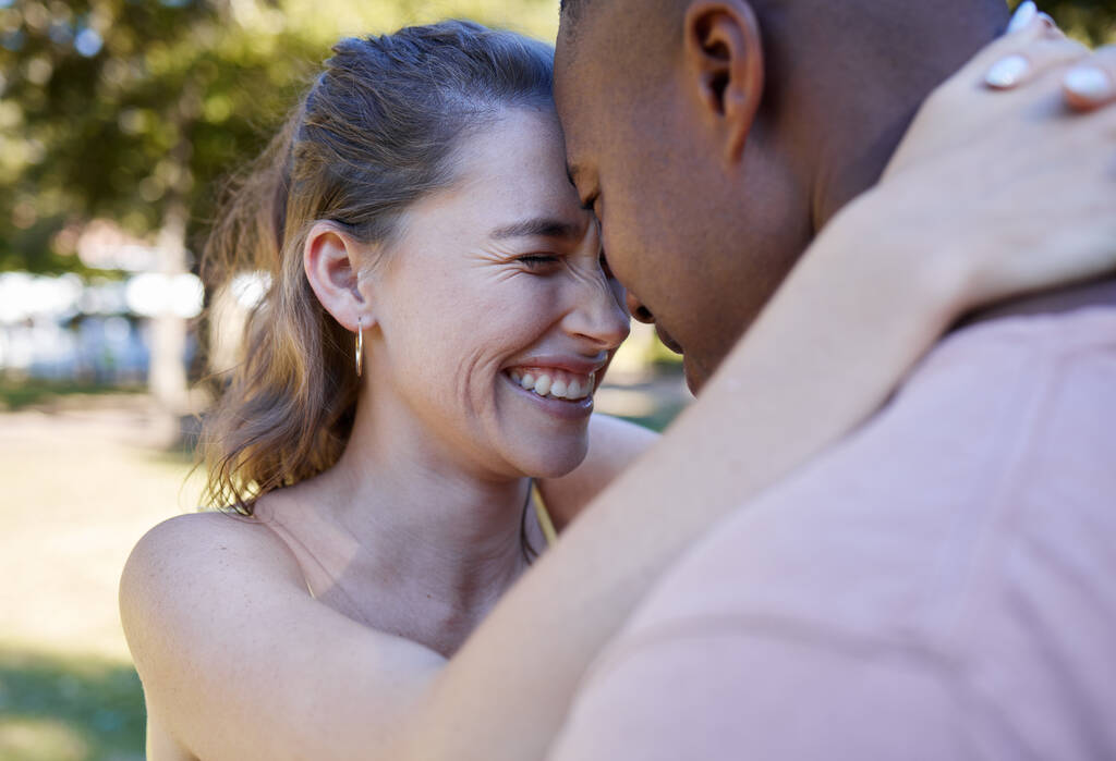 Happy, hug and interracial couple love, laugh and fun at park date in diversity, summer celebration or romance. Black man, partner or people smile together in garden excited for anniversary in nature. - Foto, Imagem