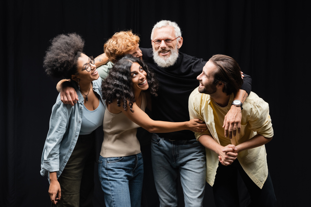 happy interracial actors hugging bearded grey haired art director in theater - Zdjęcie, obraz