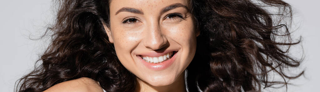 Positive young woman with freckles on face isolated on grey, banner  - Fotó, kép