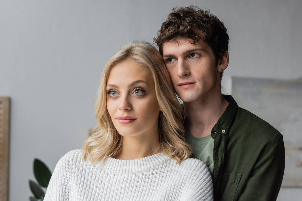 portrait of curly young man and blonde woman in white sweater  - Foto, imagen