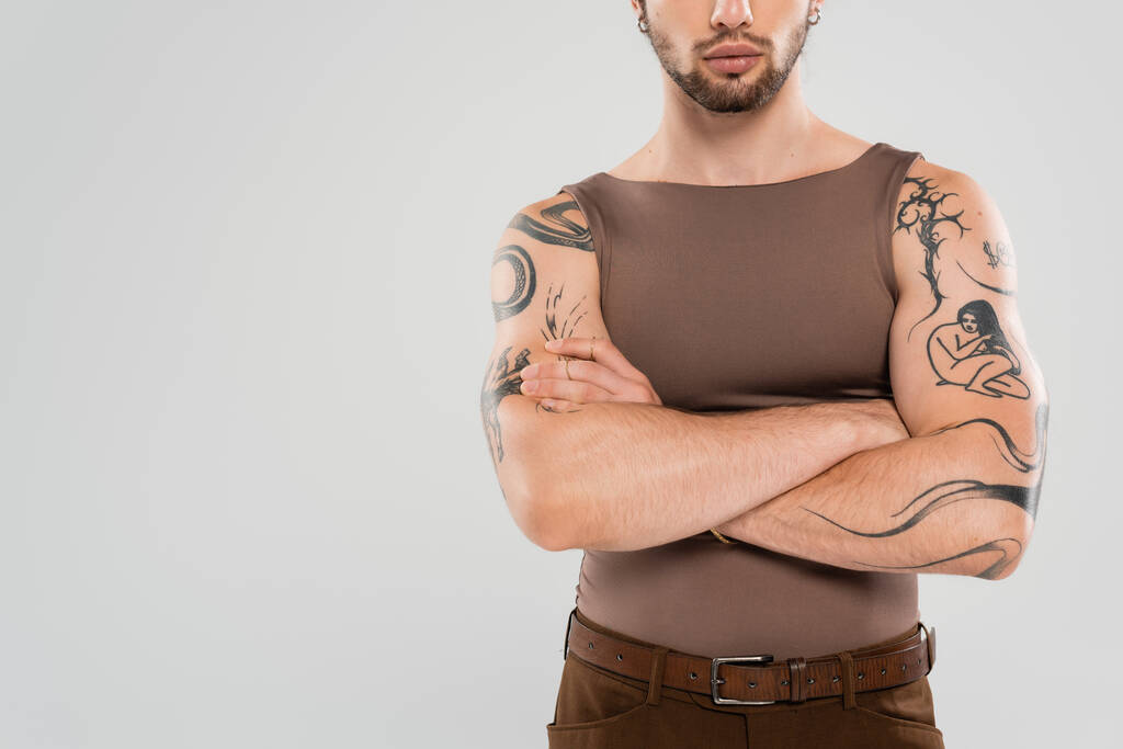 Cropped view of bearded tattooed man crossing arms isolated on grey  - Foto, Bild